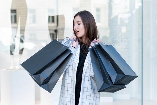 Fille Joyeuse Avec Sac à Provisions Noir Sur Fond De Vitrine. Femme élégante, Vendredi Noir.