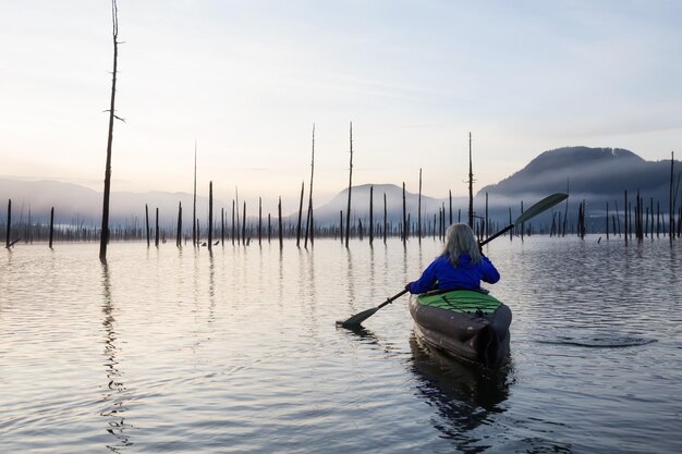 Fille kayak dans un lac