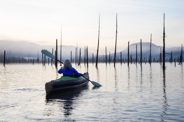 Fille kayak dans un lac