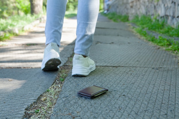 Photo la fille a laissé tomber son portefeuille et s'en va