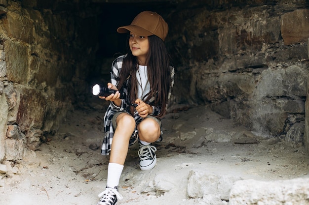 Fille avec lampe de poche dans la grotte à la recherche de l'antiquité