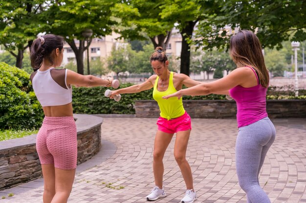 Fille latina faisant du sport dans un parc de la ville, mode de vie une vie saine, élèves enseignants faisant de l'exercice avec des poids