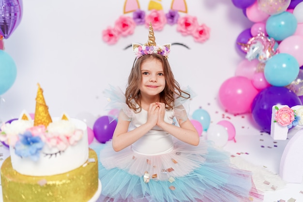 Fille licorne jette des confettis à la fête d'anniversaire