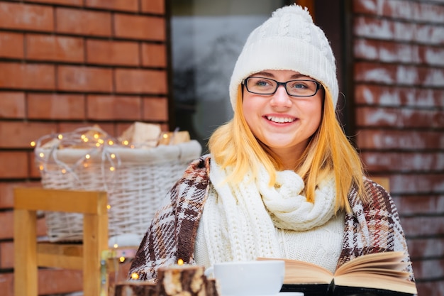 Fille lisant un livre dans un café