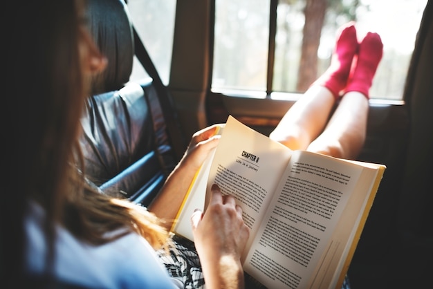 Fille lisant un livre dans une voiture