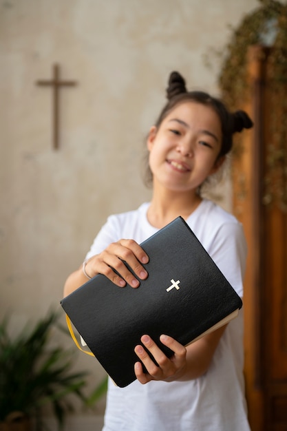 Photo fille lisant la vue de face de la bible chrétienne