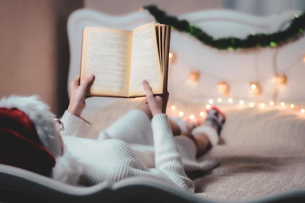 La fille lit un livre allongé sur le lit