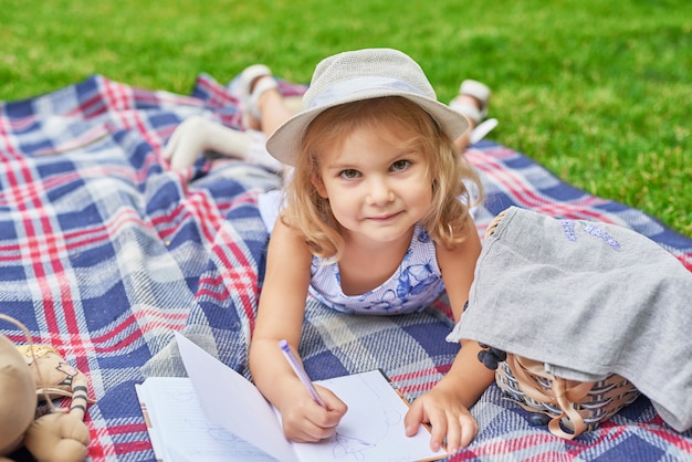 Photo fille avec un livre dans le parc sur un pique-nique