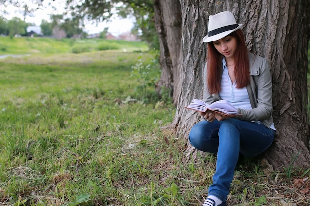 Fille avec livre dans le parc