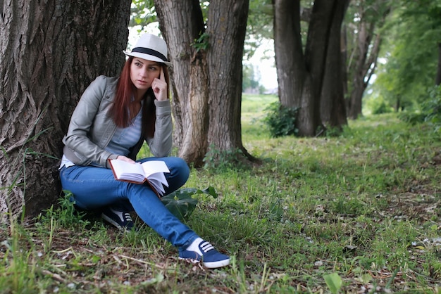 Fille avec livre dans le parc