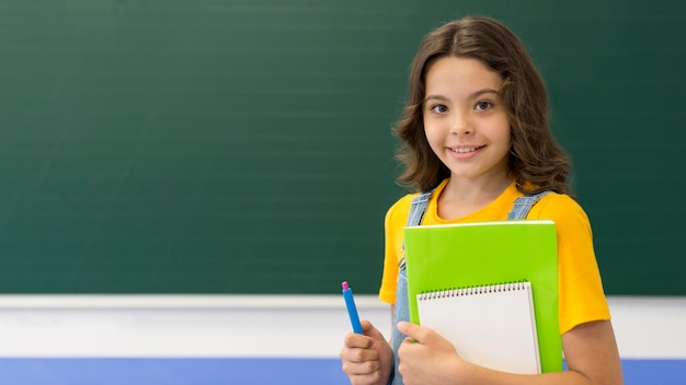 Fille avec des livres en classe