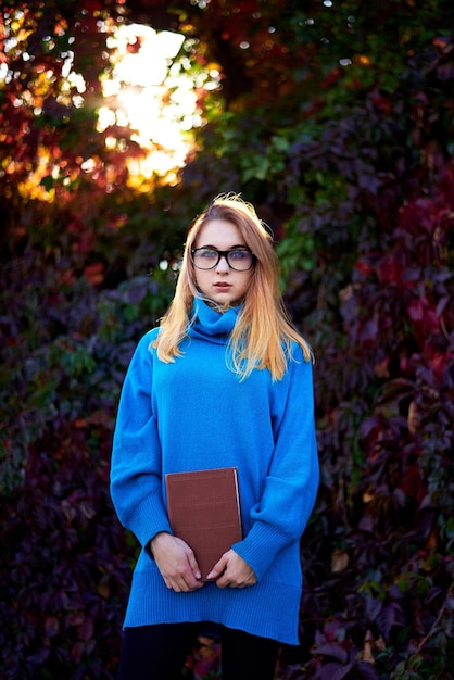 fille avec des lunettes et des livres automne