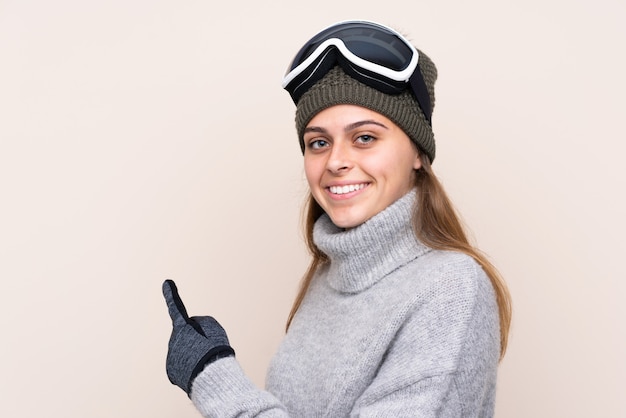 Fille avec des lunettes de neige sur mur isolé