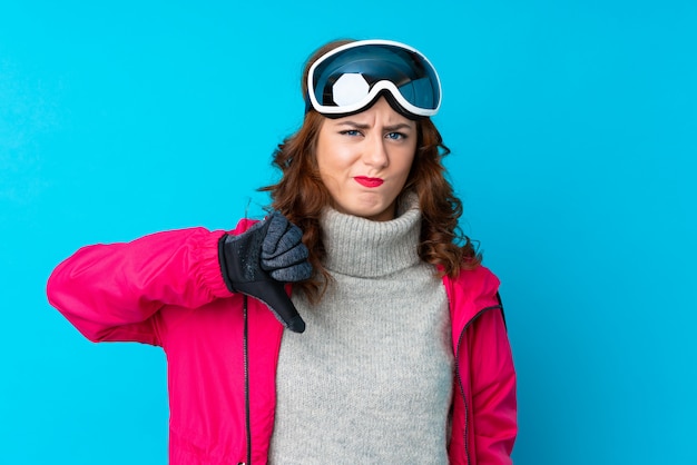 Fille avec des lunettes de neige sur mur isolé