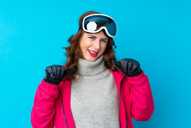 Fille avec des lunettes de neige sur mur isolé