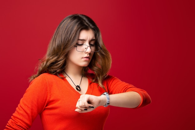 La fille à lunettes regarde la montre