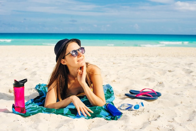 Fille à lunettes de soleil bronzer sur la plage à cancun mexique par une journée ensoleillée