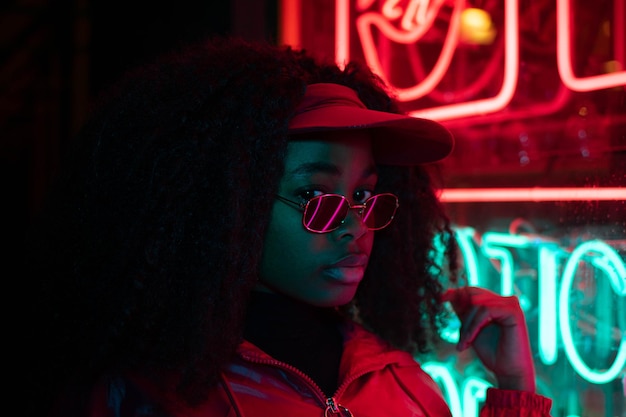 fille avec des lunettes de soleil et une frange regardant les néons