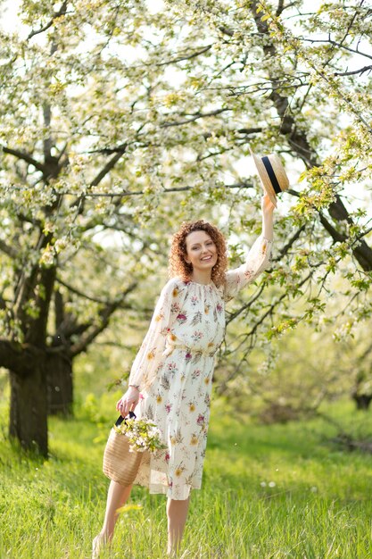 fille magnifique se promène dans un jardin de printemps fleuri. concept d'unité de l'homme avec la nature