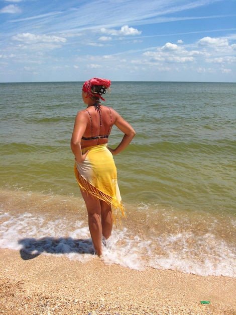 Fille en maillot de bain debout sur la côte