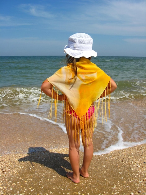 Fille en maillot de bain debout sur la côte