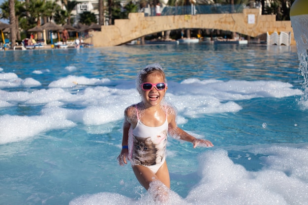 Fille en maillot de bain avec lunettes de soleil dans la piscine