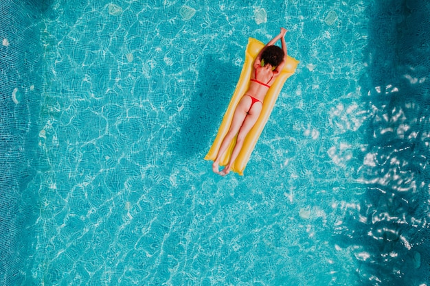 Fille en maillot de bain qui bronze dans une piscine