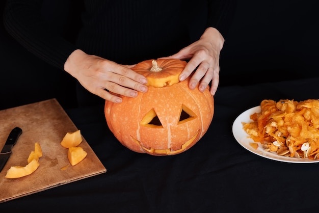 Fille mains fait une citrouille orange pour Halloween