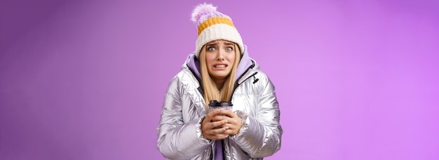 Une fille mal à l'aise, mécontente, portant un chapeau à la veste argentée, tremblant, gelée, froide, chaude.