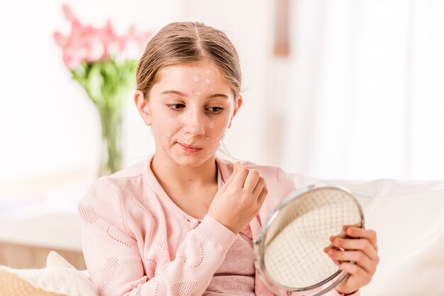 Fille malade essayant de bien paraître dans le miroir