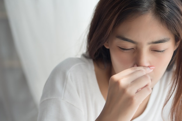 Fille malade avec nez qui coule et anosmie, perte de l'odorat en tant que symptômes d'infection COVID-19