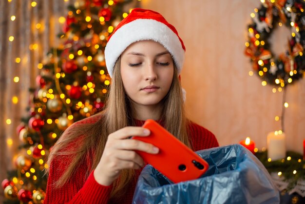 Une fille malheureuse jette un cadeau de téléphone portable rouge d'un ami insatisfait du cadeau de Noël