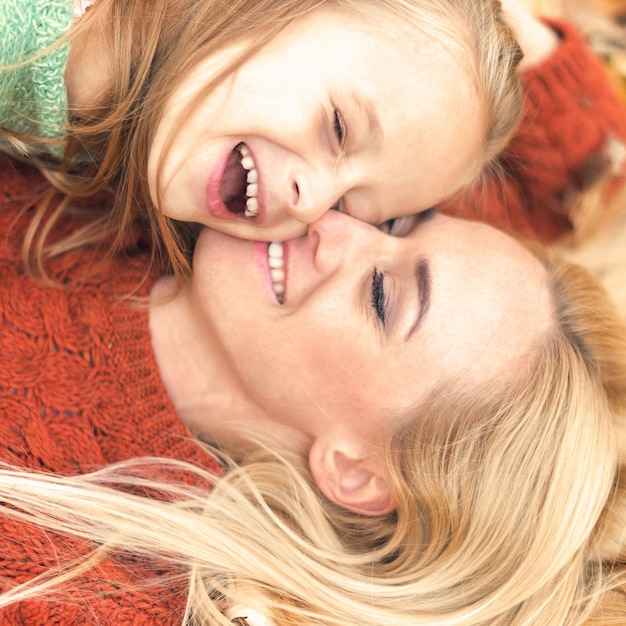 Fille et maman allongée sur les feuilles d'automne