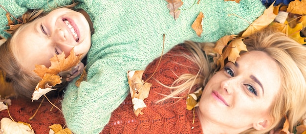 Fille et maman allongée sur les feuilles d'automne