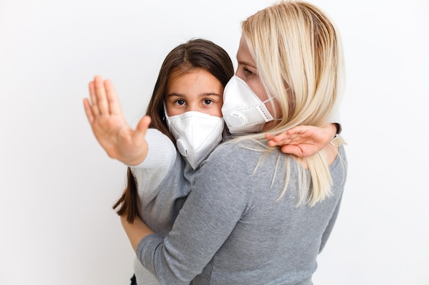 Fille avec maman en masques chirurgicaux. Famille avec enfants en masque facial ffp1. Protection contre les virus et les maladies dans les lieux publics bondés. La chambre de la mère et de la fille porte un masque de protection, des soins de santé