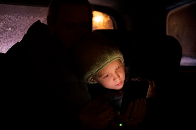 Fille et maman utilisant un smartphone en voiture