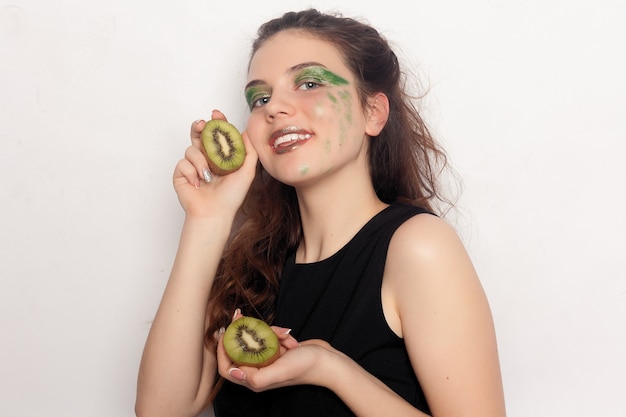 La fille mange un demi kiwi