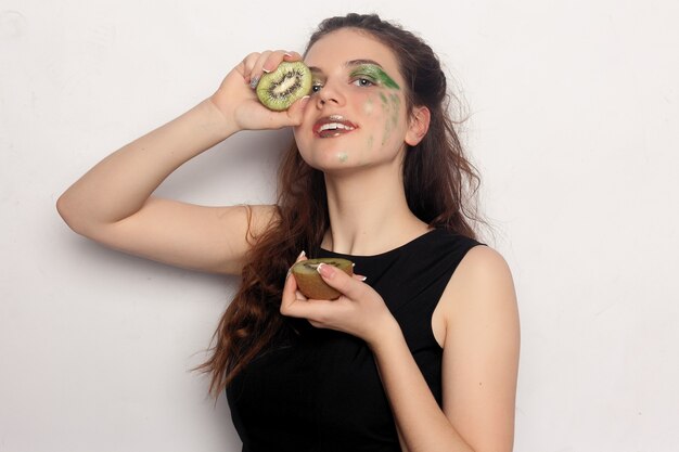 La fille mange un demi kiwi