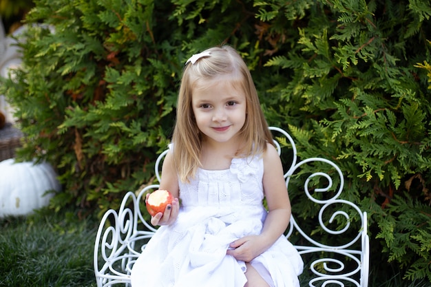 Fille mange une pomme dans le jardin