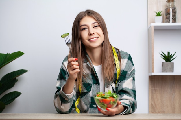 Fille mange une salade de légumes avec beaucoup de vitamines