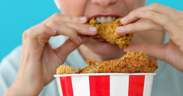 Fille mangeant des ailes de poulet