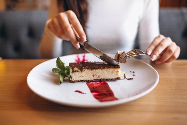 Fille mangeant un gâteau dans un café