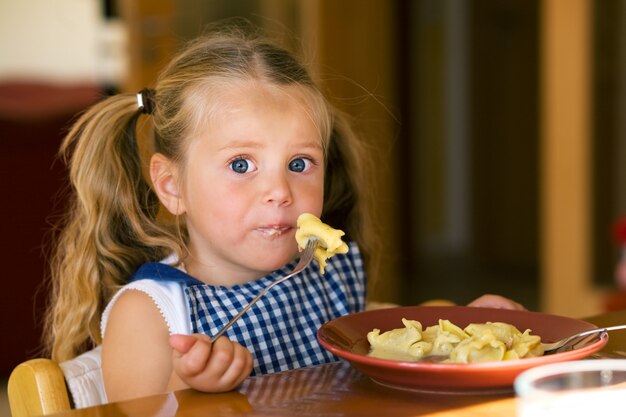 Fille mangeant des pâtes