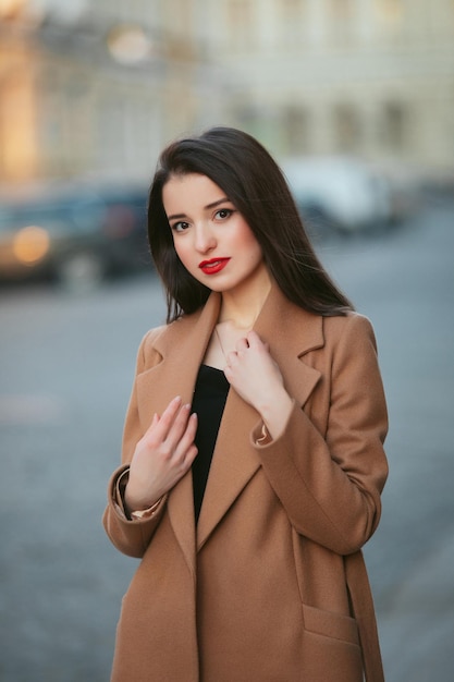 Fille en manteau dans la rue au lever du soleil