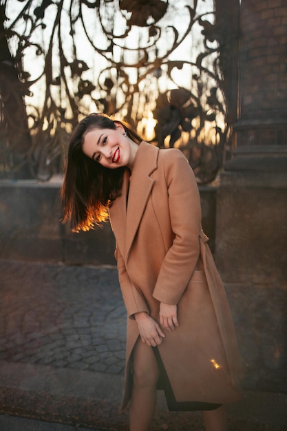 Fille en manteau dans la rue au lever du soleil