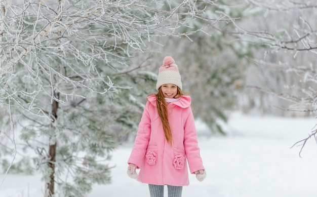 Fille en manteau rose appréciant d'être à l'extérieur