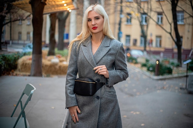 Une fille en manteau se promène dans la ville d'automne