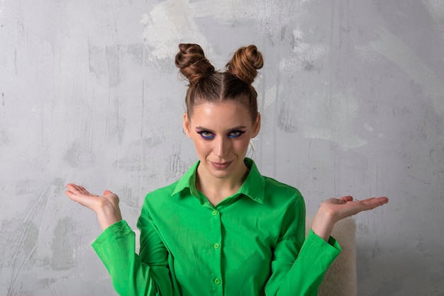 Fille avec maquillage lumineux et coiffure chignon en chemise verte Placez votre texte Fond gris