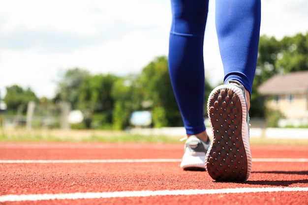 Fille marchant sur une piste d'athlétisme rouge, espace pour le texte