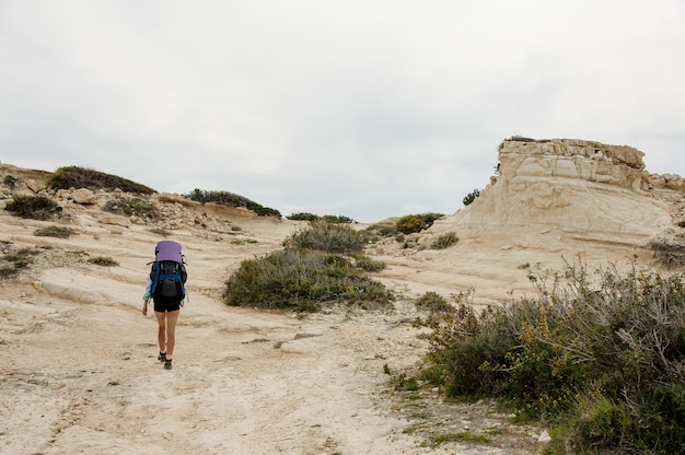 Fille marchant sur les rochers avec sac à dos de randonnée